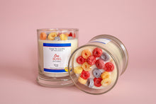 Load image into Gallery viewer, Candle with a fruit cereal design with a label on a pinkbackground